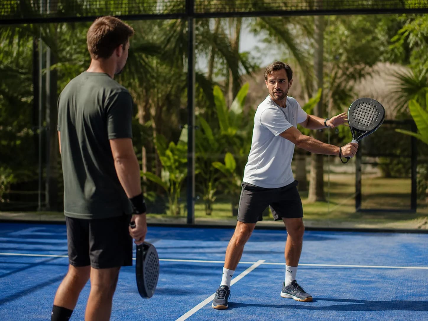 Coach demonstrating a forehand during a private padel lesson